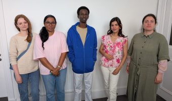 Five members of the ESOL class standing in a row smiling for the camera